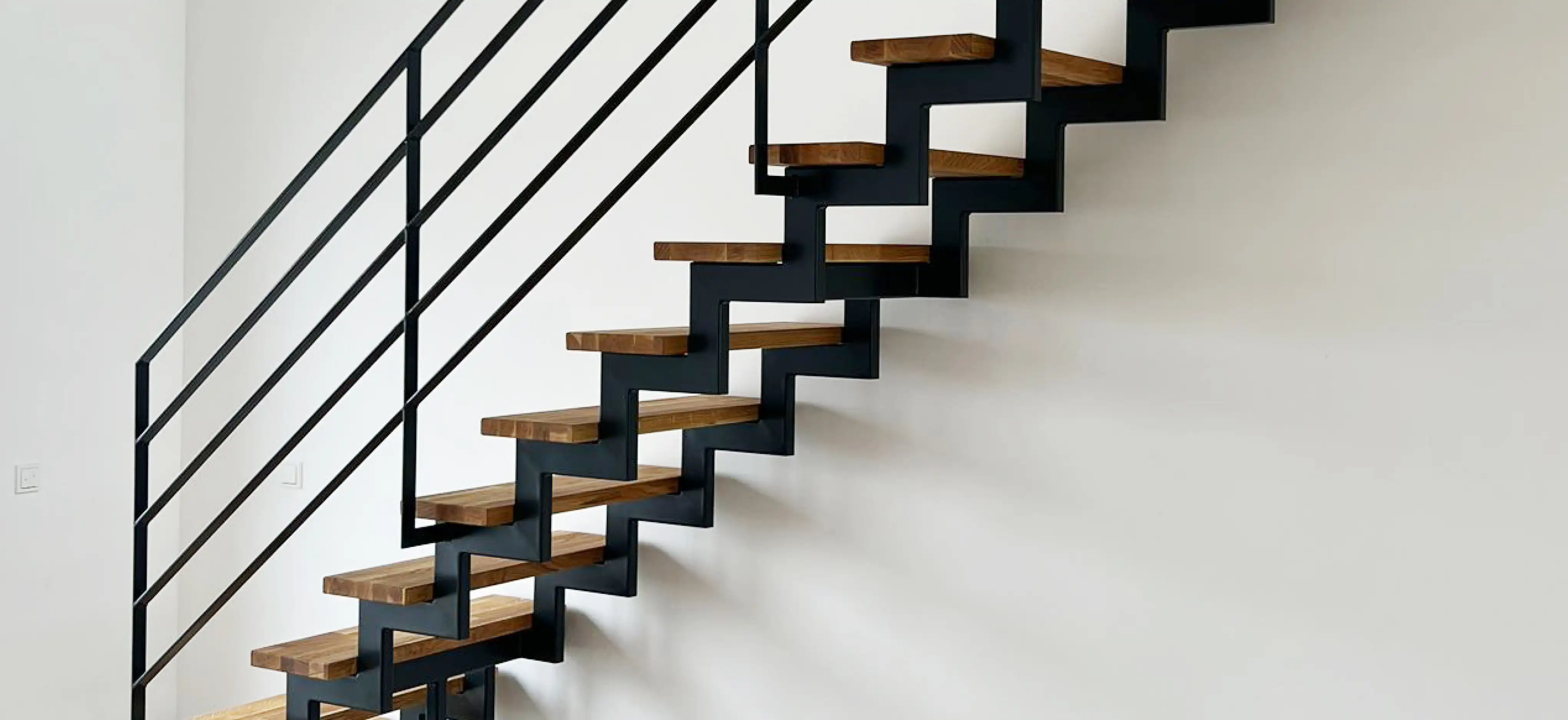 Zweiholmtreppe mit sichtbaren Stahlholmen und Holzstufen in einem modernen Innenraum