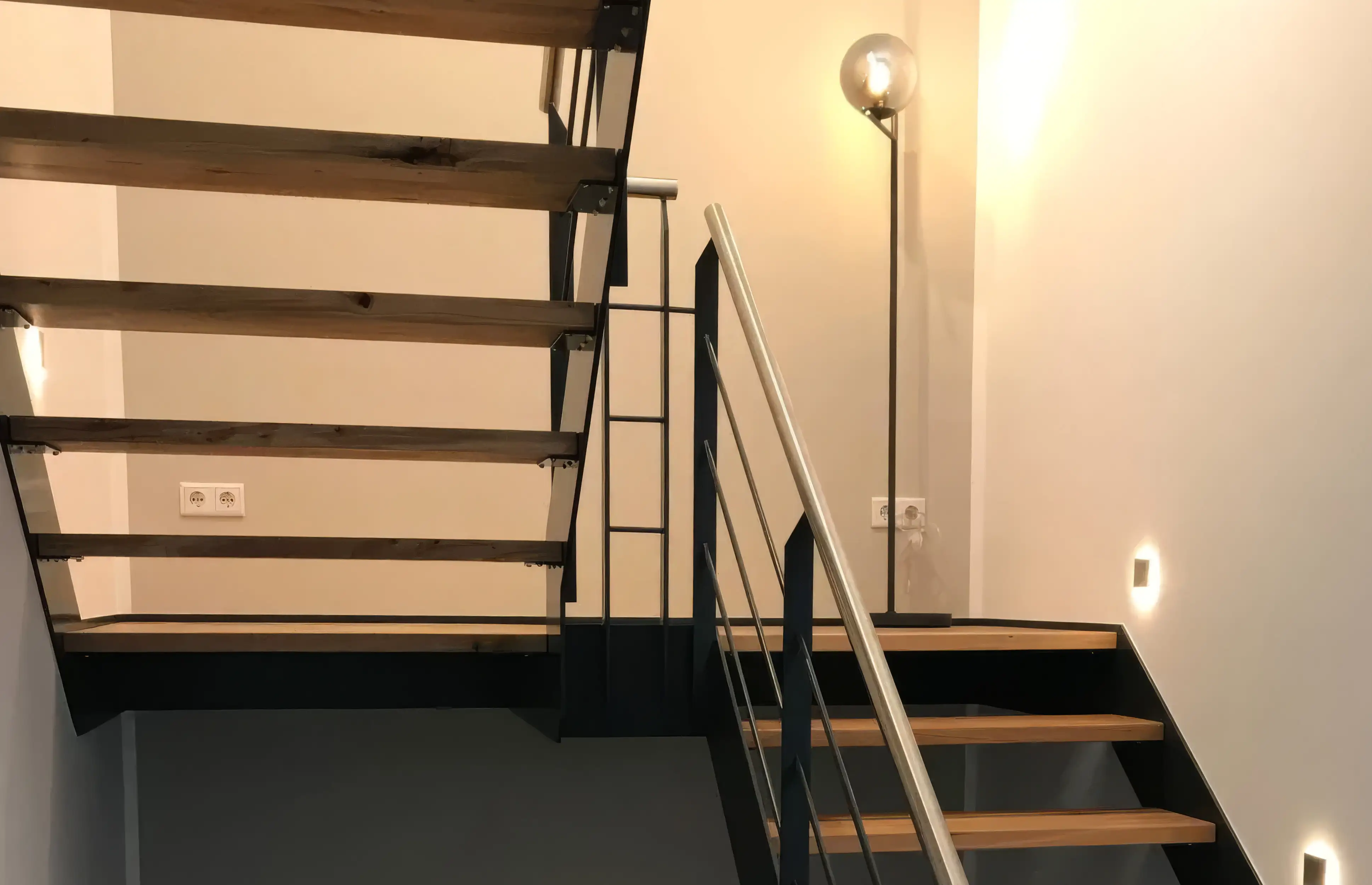 Wangentreppe aus Stahl mit Podest, ausgestattet mit Stufen aus Eiche und einem Podest aus Eichenholz von Janßen Metallbau Xanten