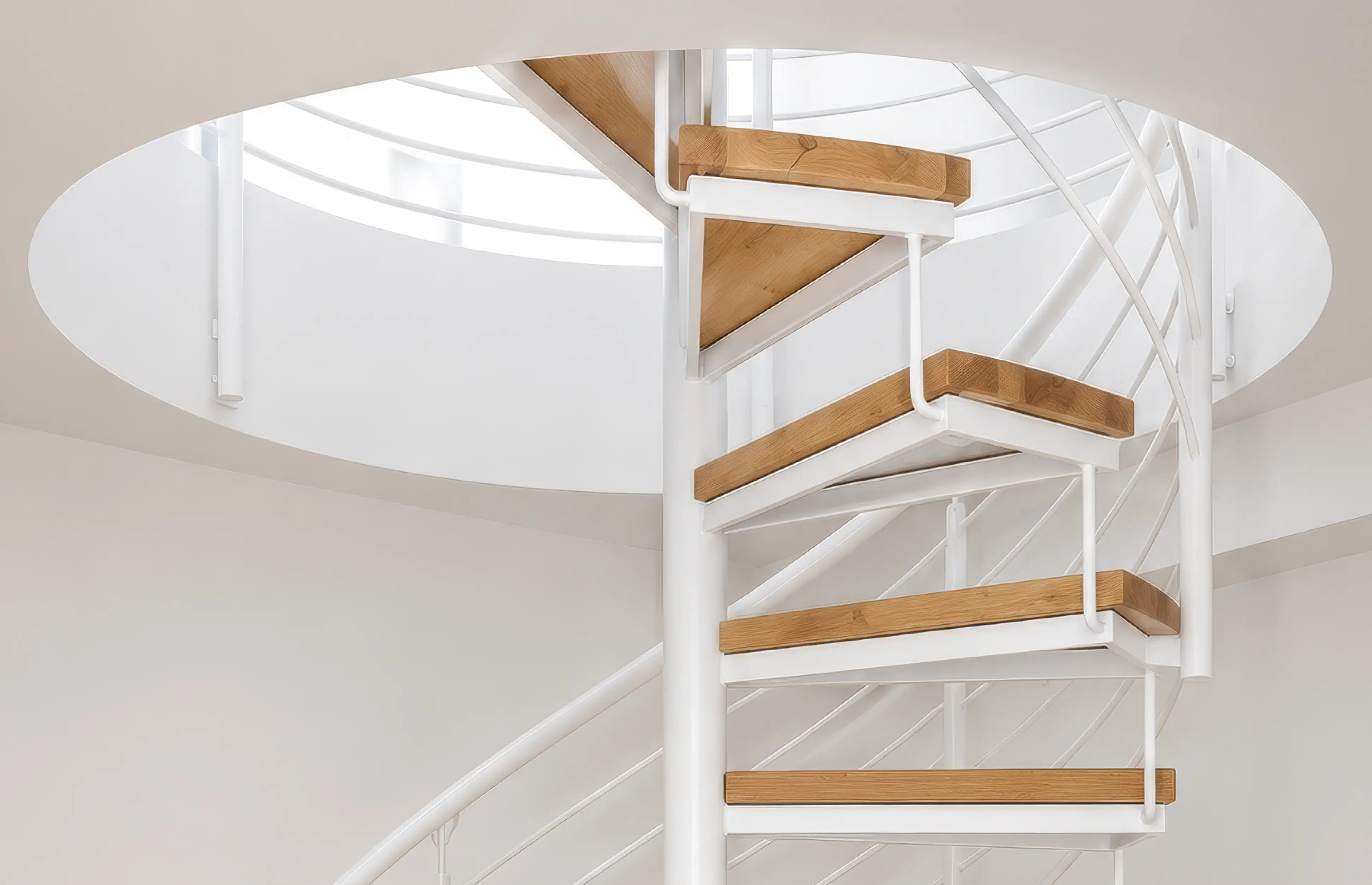 Spindeltreppe mit schwarzem Stahlgeländer und Holzstufen aus Buche