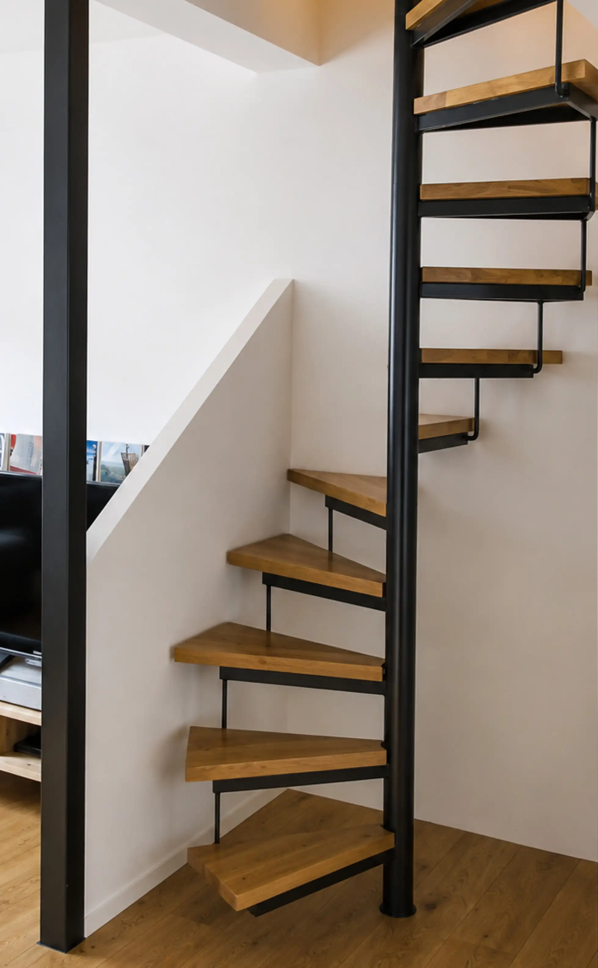 Schmale Spindeltreppe als Raumspartreppe, mit Holzstufen im Wohnbereich
