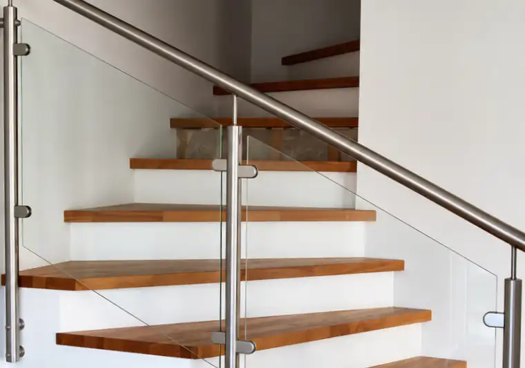 Glasgeländer mit Edelstahlpfosten und Edelstahlhandlauf an einer Betontreppe