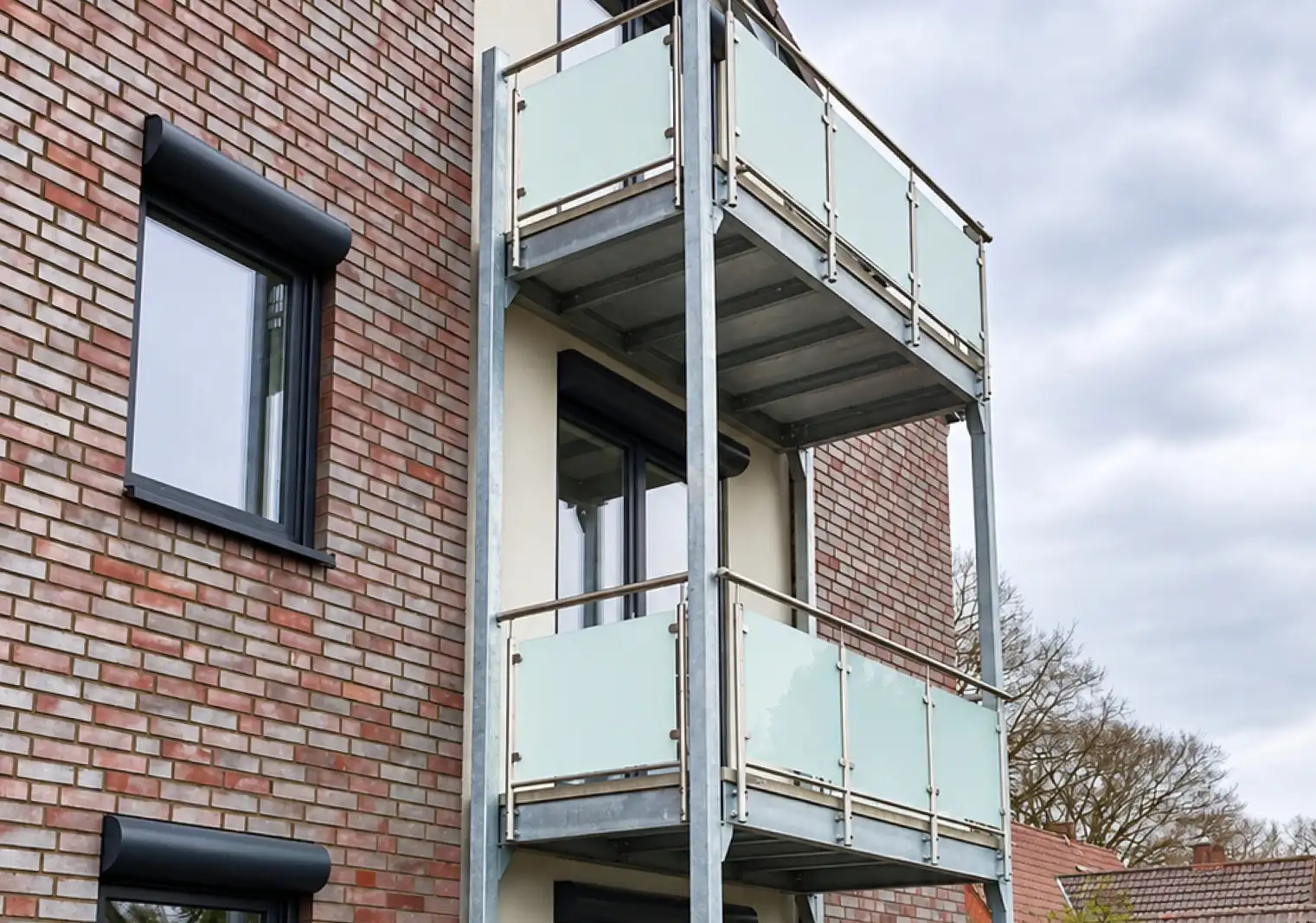 Vorstellbalkon aus verzinktem Stahl mit Glasgeländer und Edelstahlhandlauf
